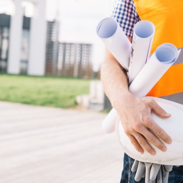 crop-man-with-blueprints-helmet